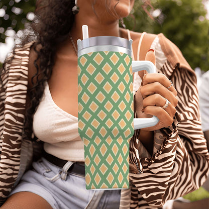 Person holding a green and orange patterned tumbler outdoors