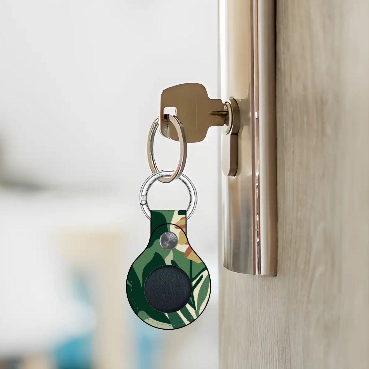 Keychain with a green leaf pattern attached to a door handle.