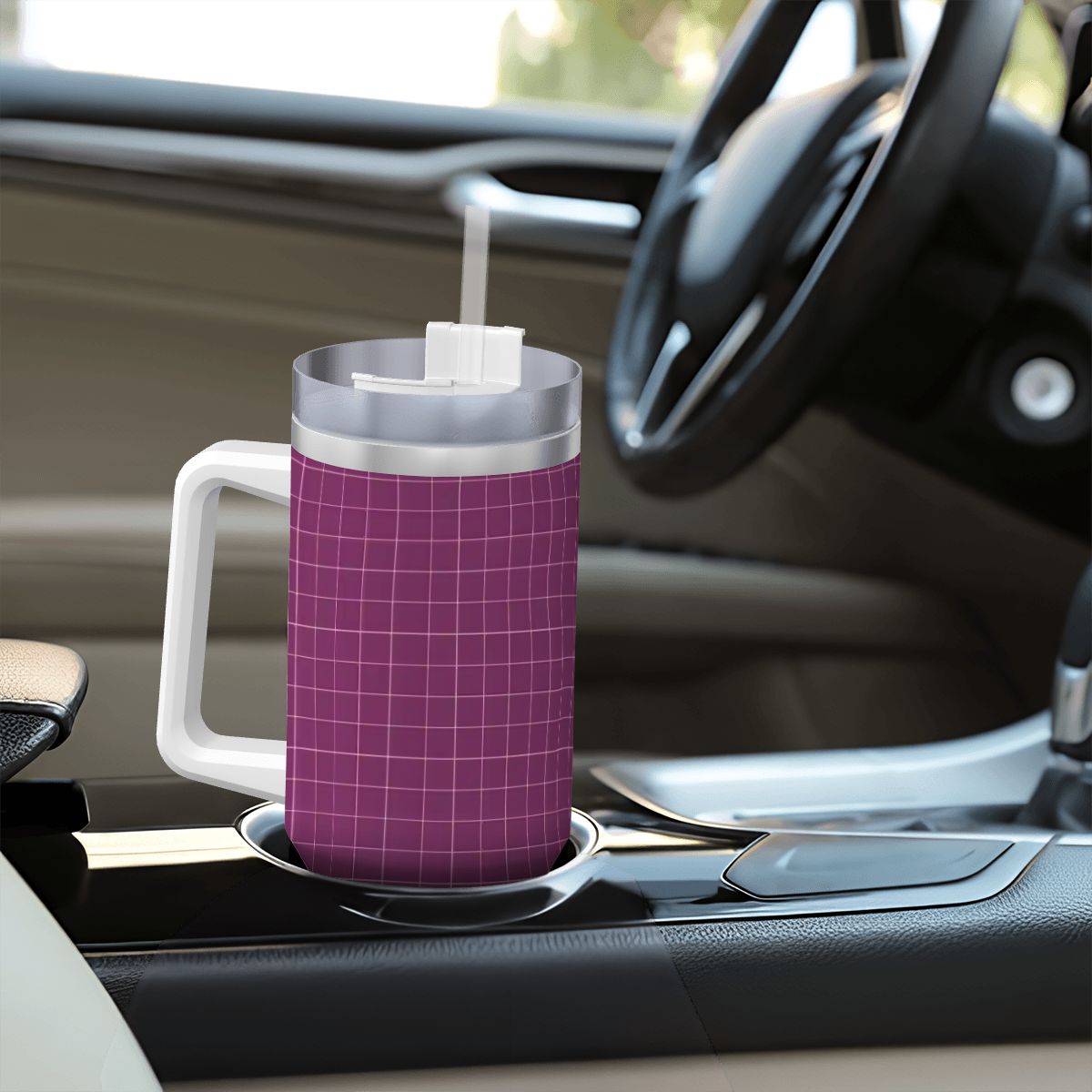 Purple grid-patterned mug with a straw on a car cup holder