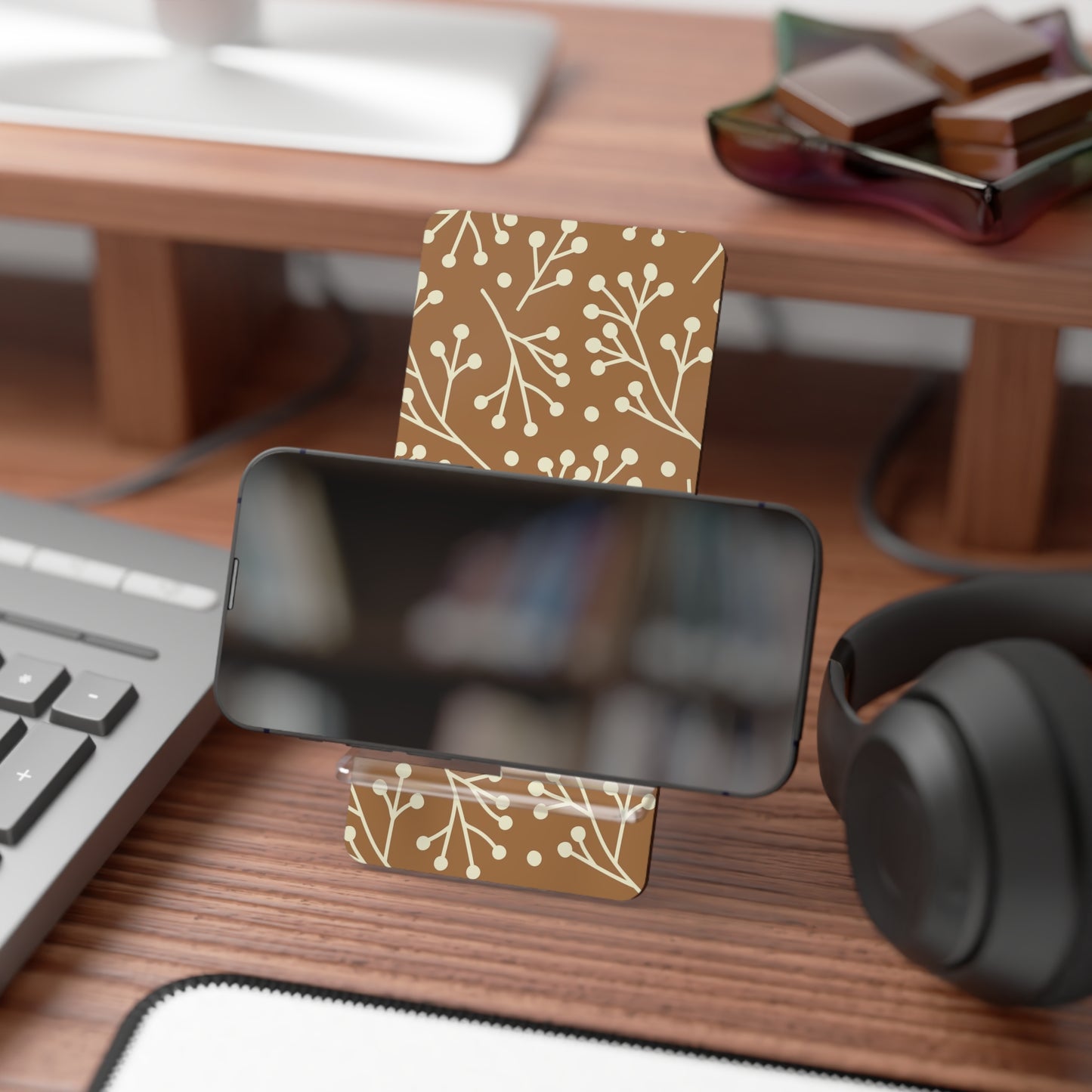 Business card holder with floral design on a desk with computer and headphones