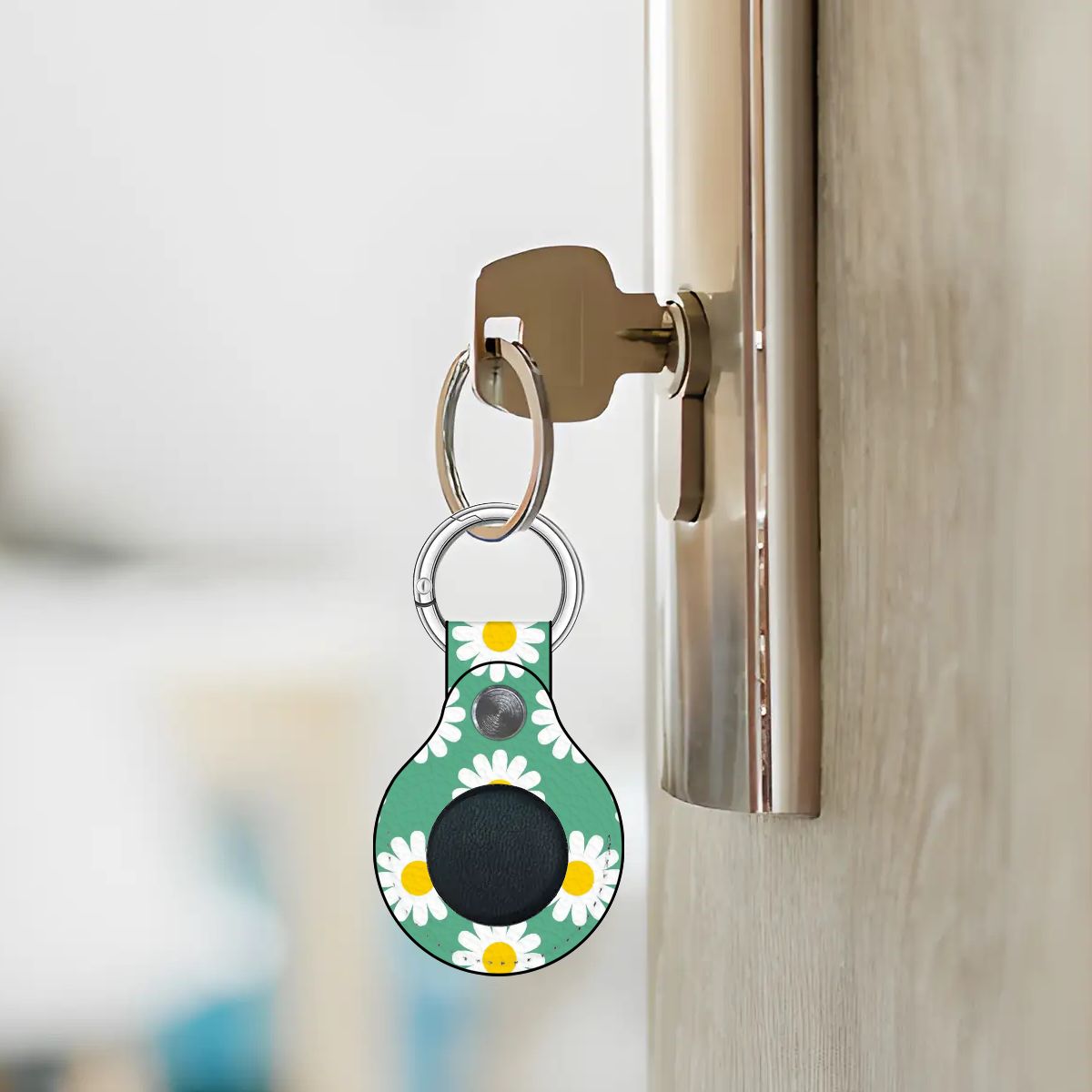 Keychain with a floral design attached to a door handle.