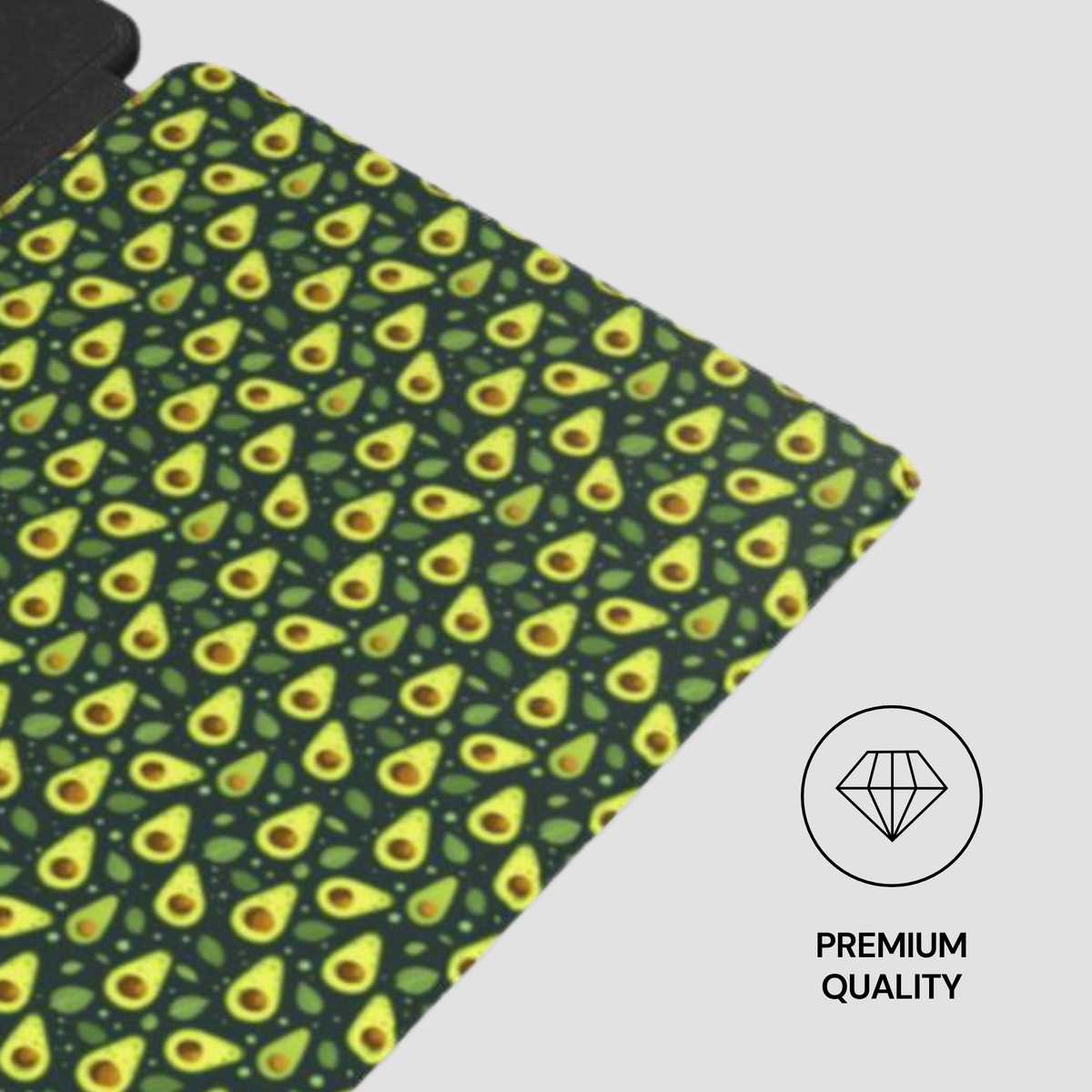 A close-up of a fabric or mat with a repeating avocado print on a dark green background, shown at an angle on a light gray background with a 'PREMIUM QUALITY' diamond icon overlay.