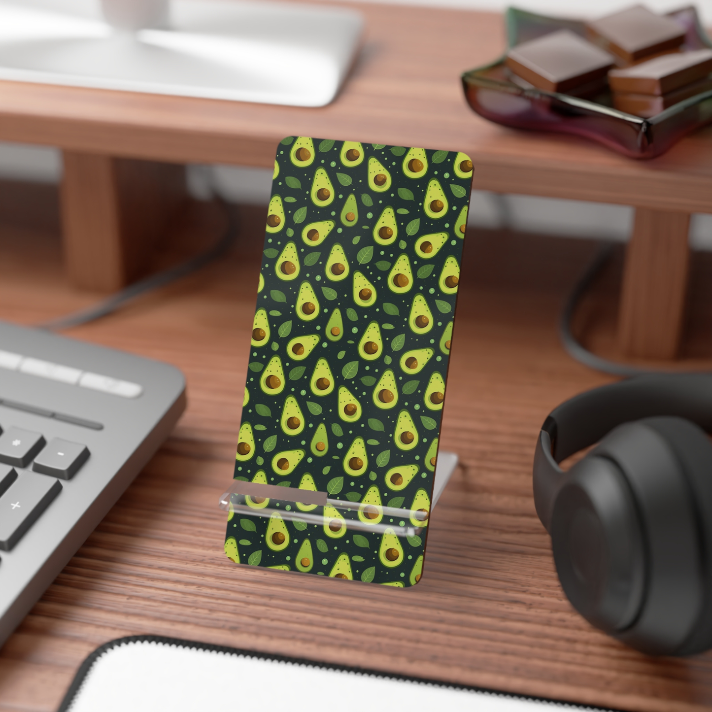 Phone case with avocado pattern on a desk with keyboard and headphones