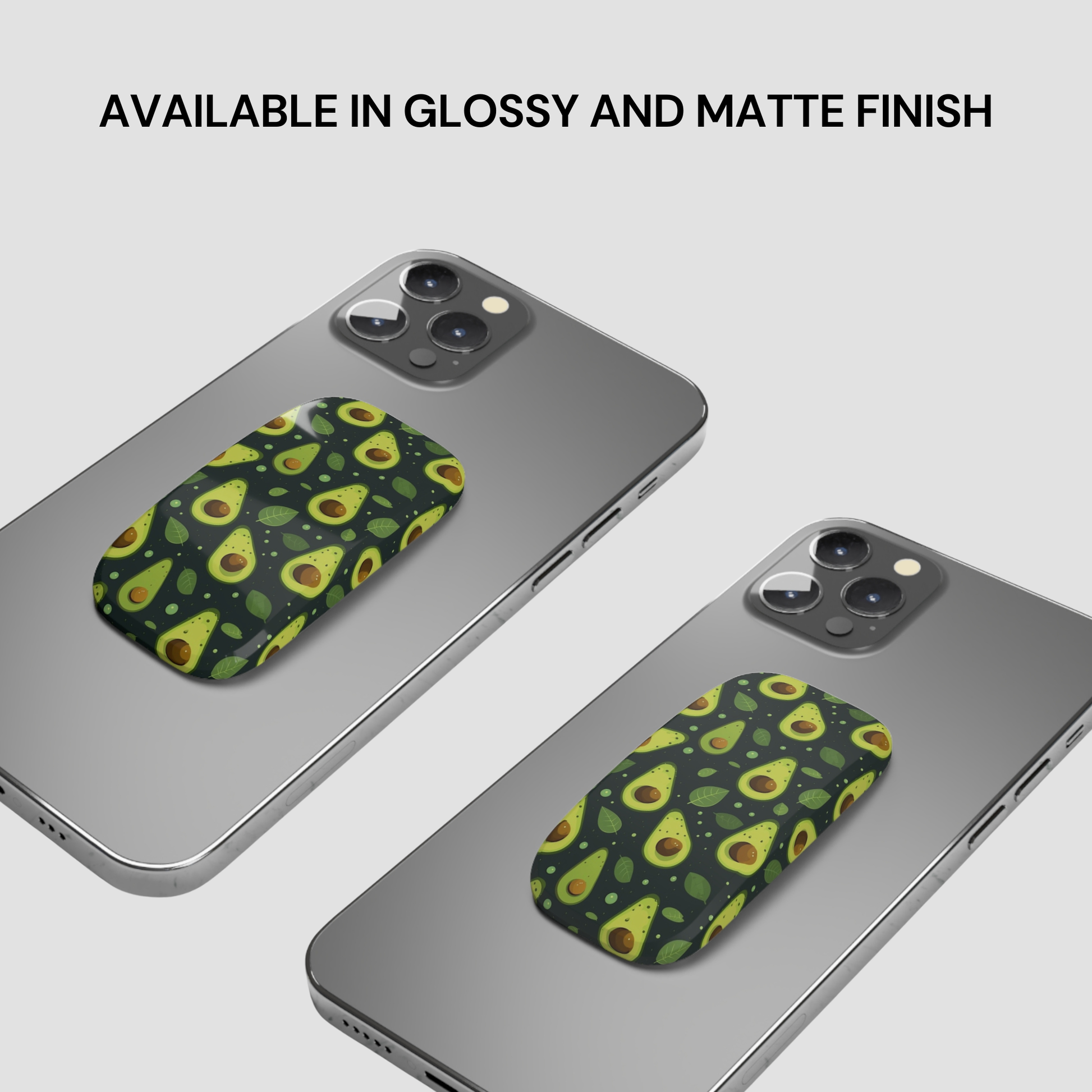 Two gray smartphones shown at an angle on a light gray background, each with a green avocado-patterned pop socket attached. Text at the top reads 'AVAILABLE IN GLOSSY AND MATTE FINISH'.