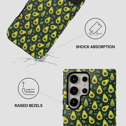 A phone case with a green avocado print pattern, shown on a light gray background with feature callouts: one case is angled above the ground with a crack and the text 'SHOCK ABSORPTION,' and another is shown from the back fitted on a phone with the text 'RAISED BEZELS.'.