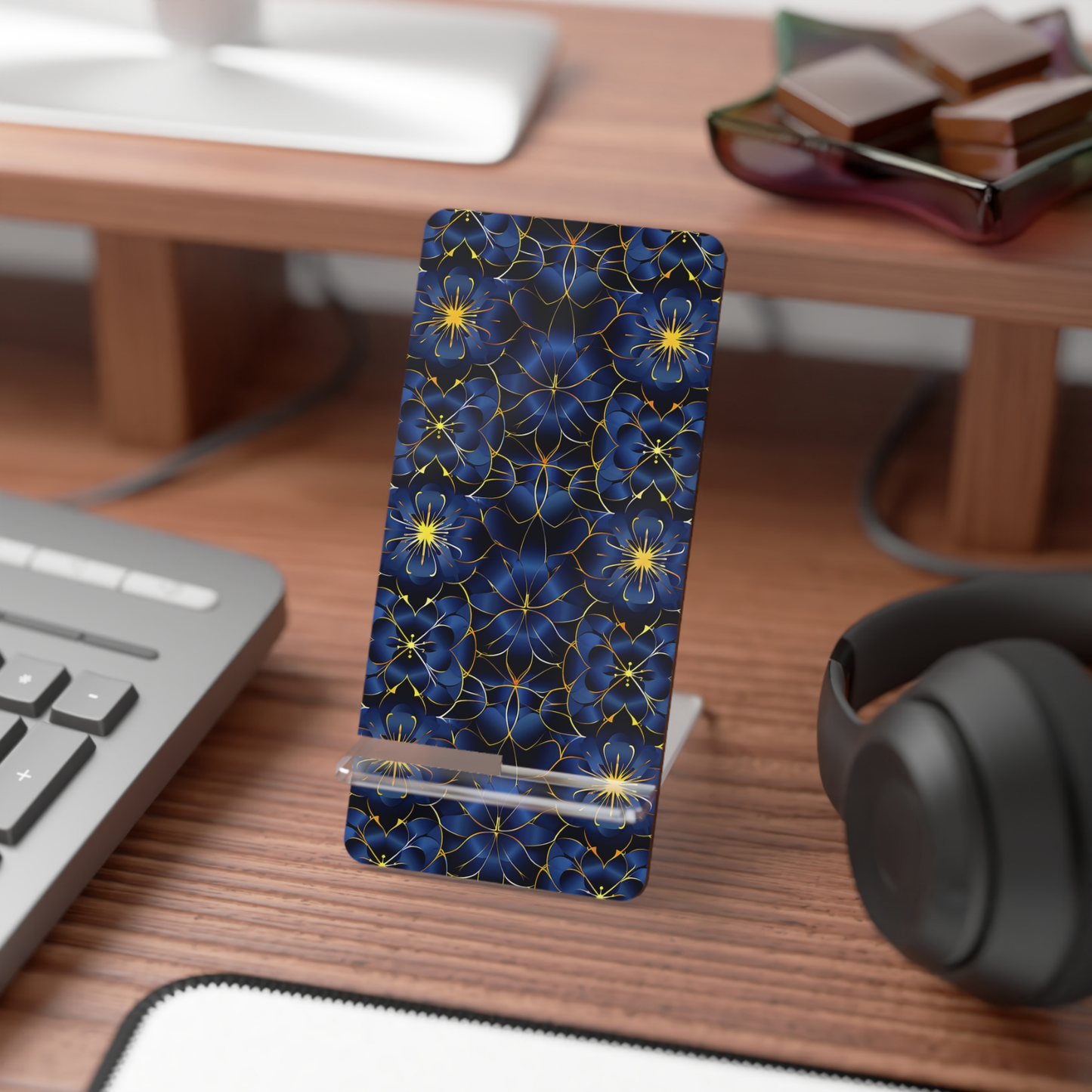 Phone case with blue floral pattern on a desk with keyboard and headphones