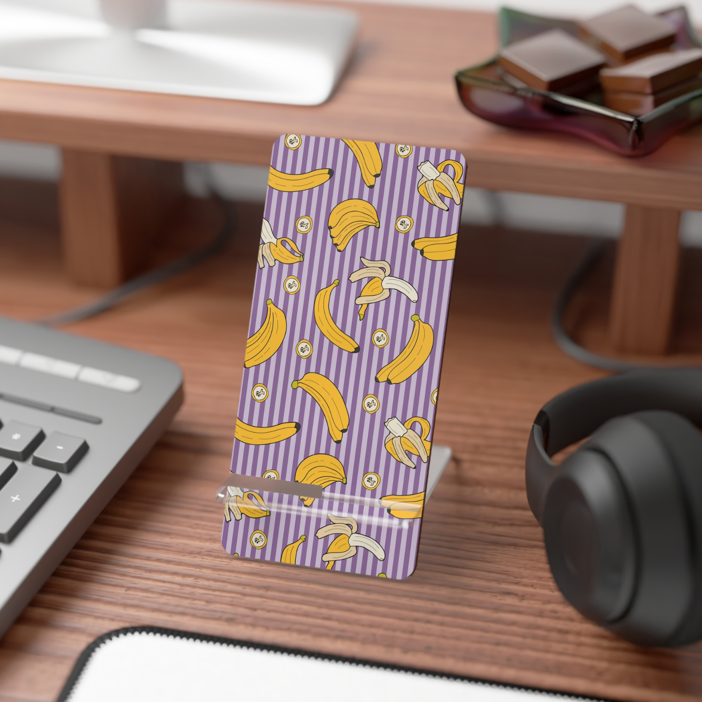 Phone case with banana pattern on a desk with keyboard and headphones