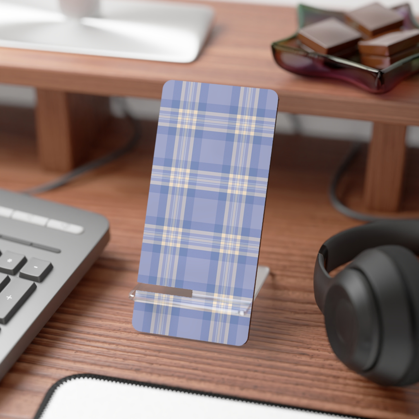 Blue plaid phone stand on a desk with a keyboard, mouse, and headphones.