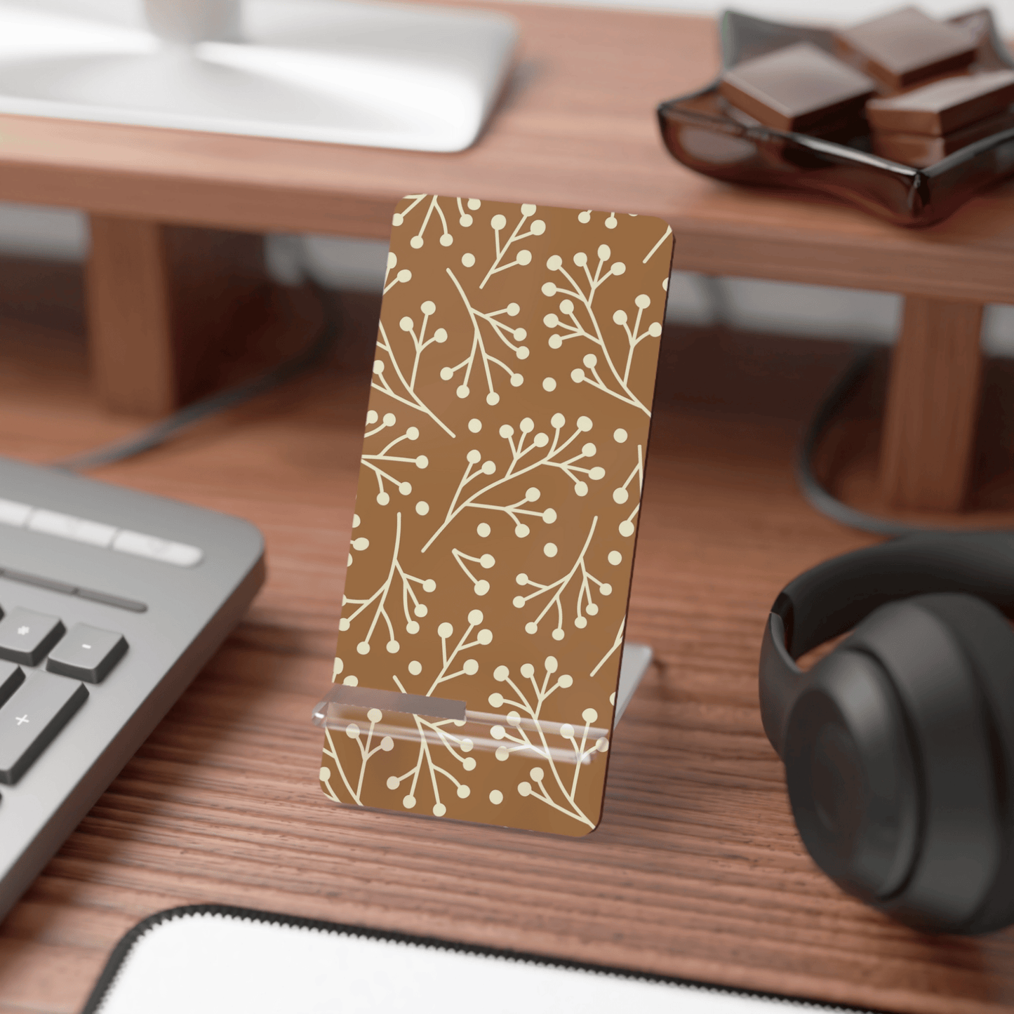 Phone stand with floral pattern on a desk with computer and headphones