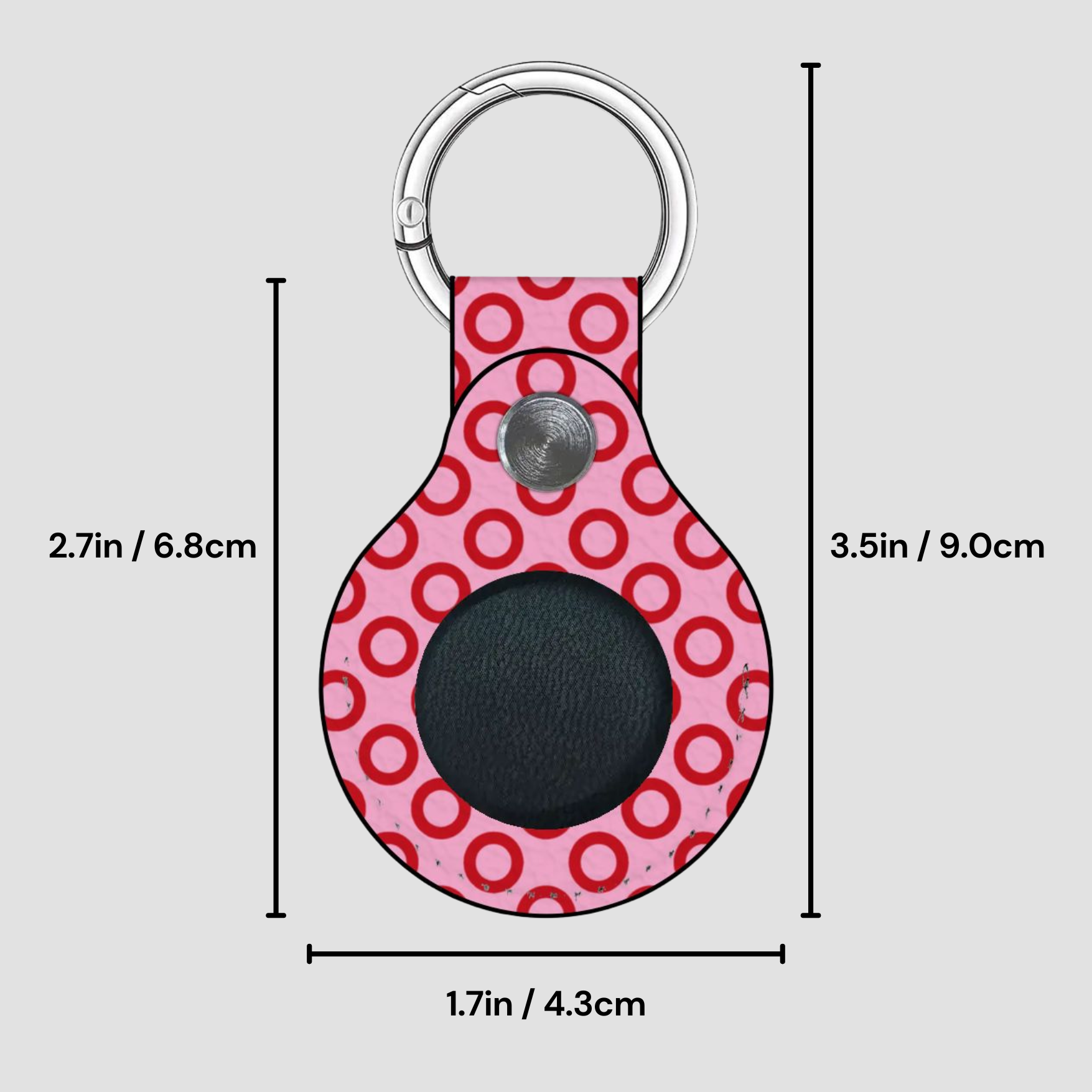 Pink circular keychain with measurements on a gray background