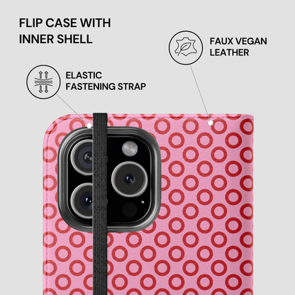 Pink flip case with red circular pattern and elastic fastening strap on a white background
