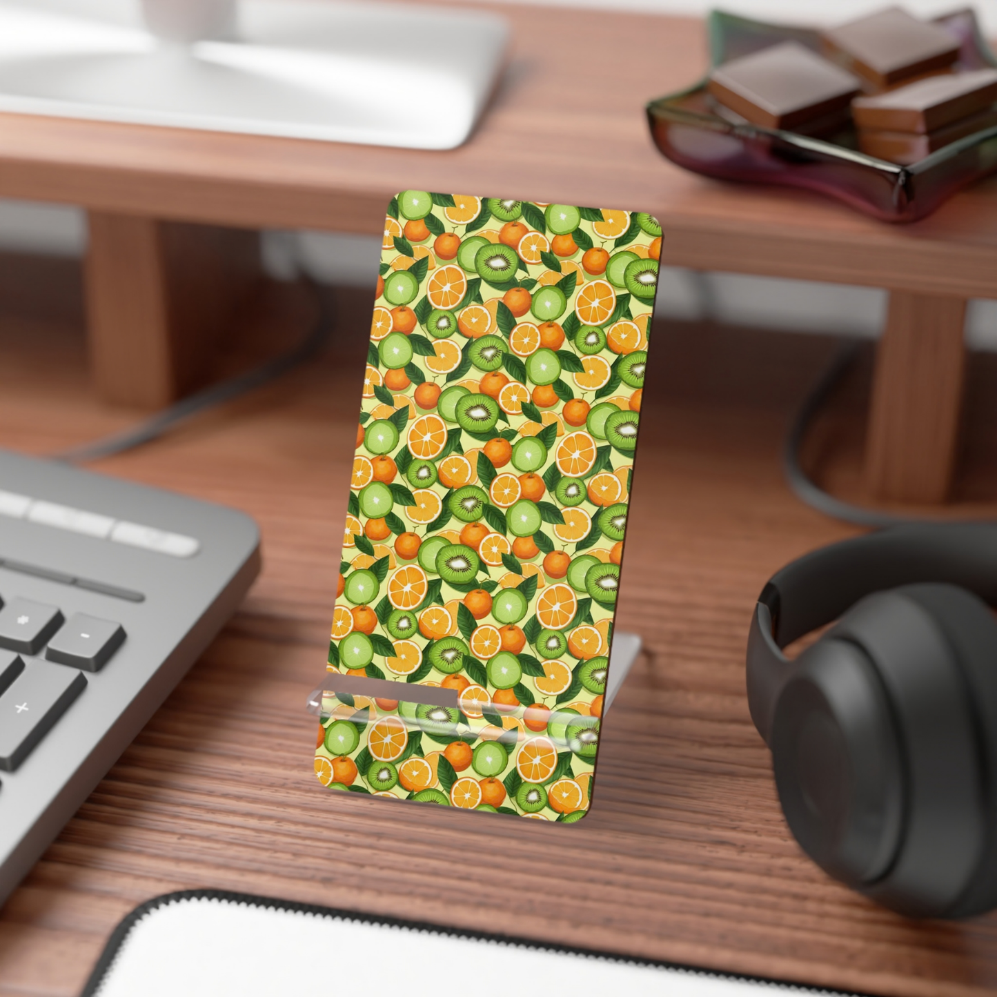 Phone case with fruit pattern on a desk with keyboard and headphones