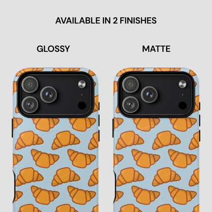 Two phone cases with croissant pattern, one glossy and one matte, on a light blue background. | Casenari