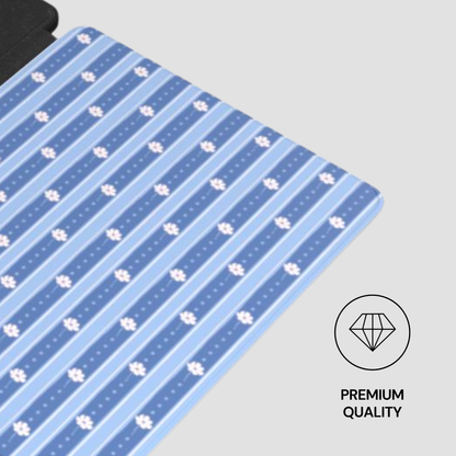 A close-up of a blue patterned fabric or mat with alternating light and dark blue stripes and small white paw-print motifs, shown on a light gray background with a 'PREMIUM QUALITY' diamond icon in the lower right.