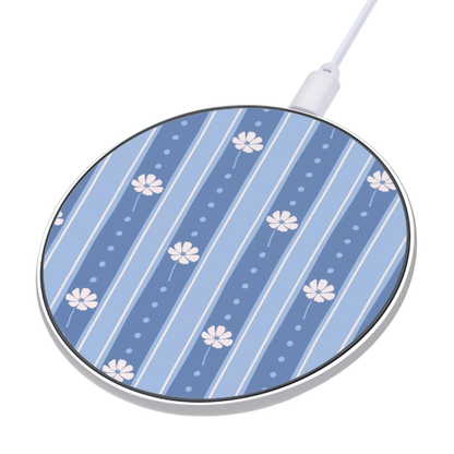 A round wireless charging pad with a blue and white floral stripe pattern, featuring a white charging cable connected at the top, shown on a plain white background.