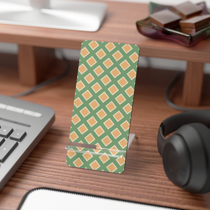 Desk setup with a green and orange patterned phone stand, keyboard, mouse, and headphones.