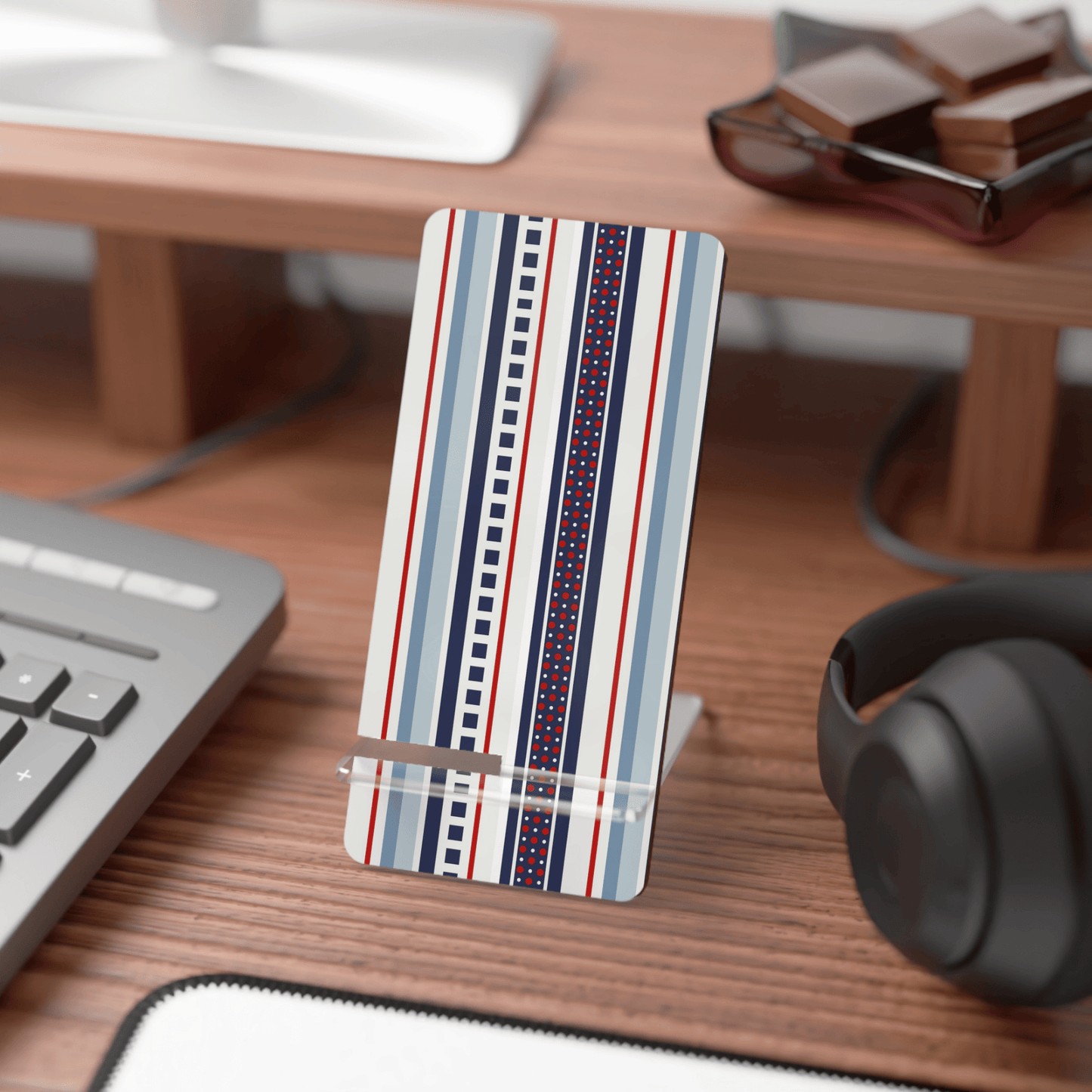 Striped phone stand on a desk with keyboard, mouse, and headphones