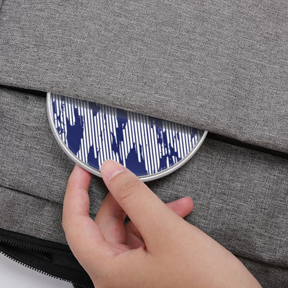 Hand placing a blue and white patterned object into a gray fabric bag.