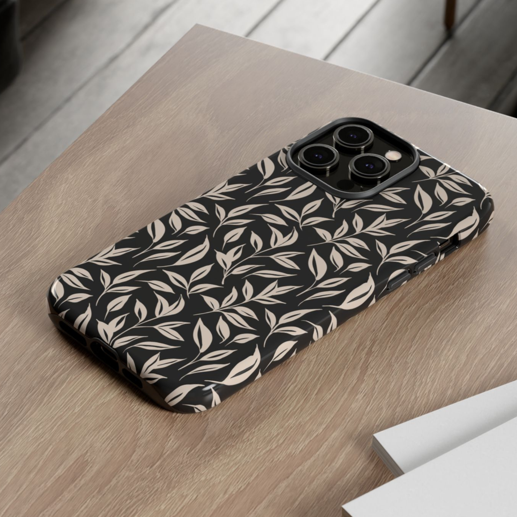 Phone case with leaf pattern on a wooden surface