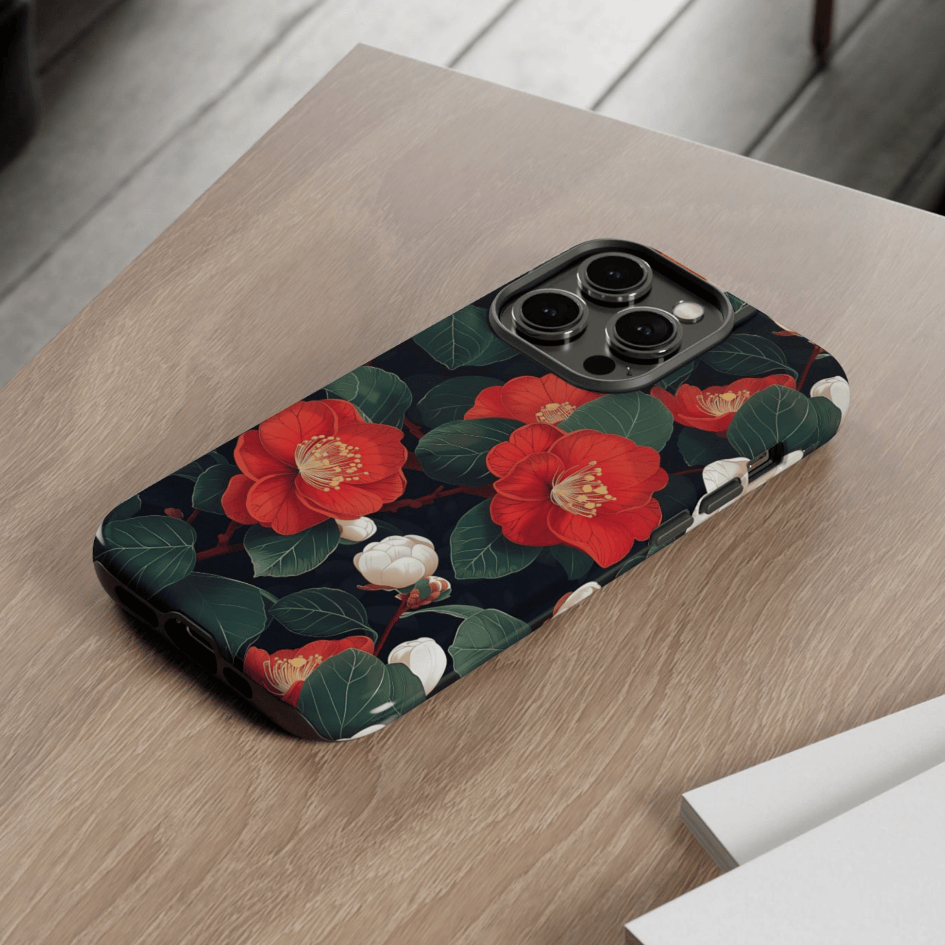 Phone case with red floral design on a wooden surface