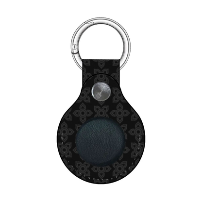 Black leather keychain with silver metal ring and button on a white background
