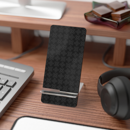 Black phone stand on a desk with a keyboard, mouse, and headphones.