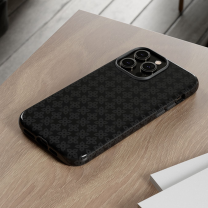 Black phone case with geometric pattern on a wooden surface