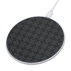 Black wireless charging pad with white cable on a white background