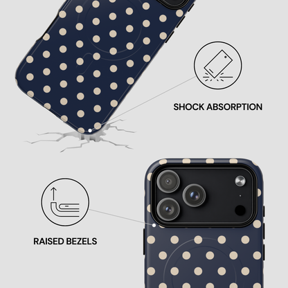Navy blue phone case with white polka dots featuring shock absorption and raised bezels on a light gray background.