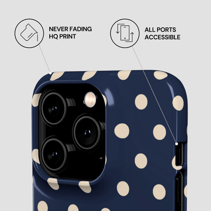 Navy blue phone case with white polka dots on a light gray background