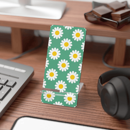 Desk with a phone stand featuring daisy pattern, keyboard, and headphones.