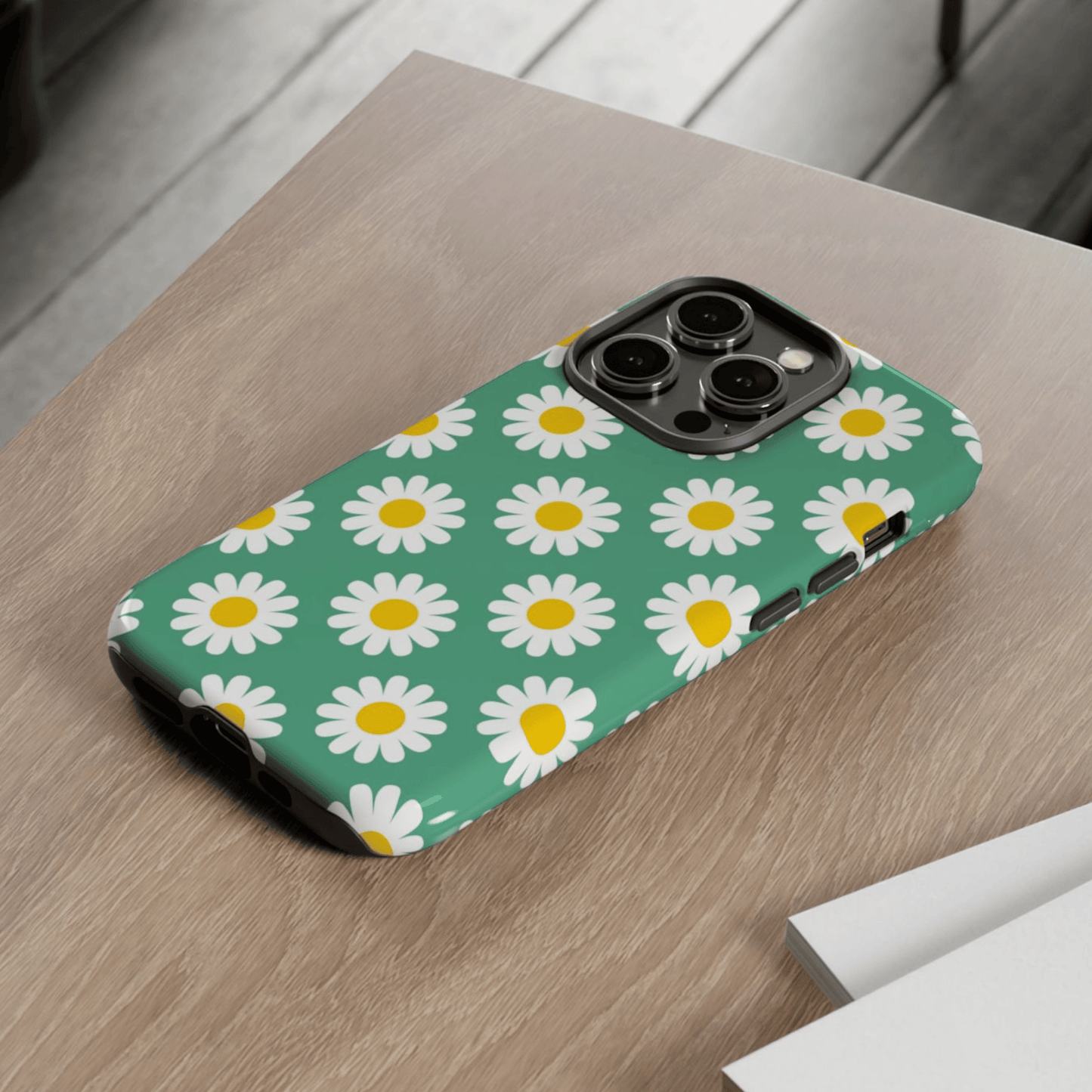 Phone case with daisy pattern on a wooden surface