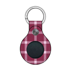 Plaid patterned keychain with a circular black center on a white background