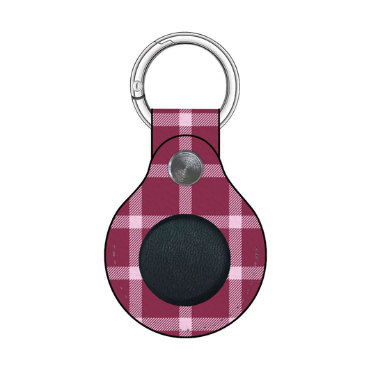 Plaid patterned keychain with a circular black center on a white background