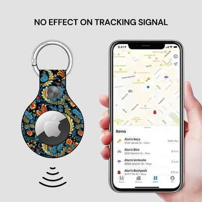 Smart keychain with floral design and phone displaying location app on a light gray background