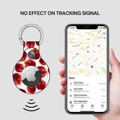 Smart keychain with fruit design and phone app showing location tracking on a gray background