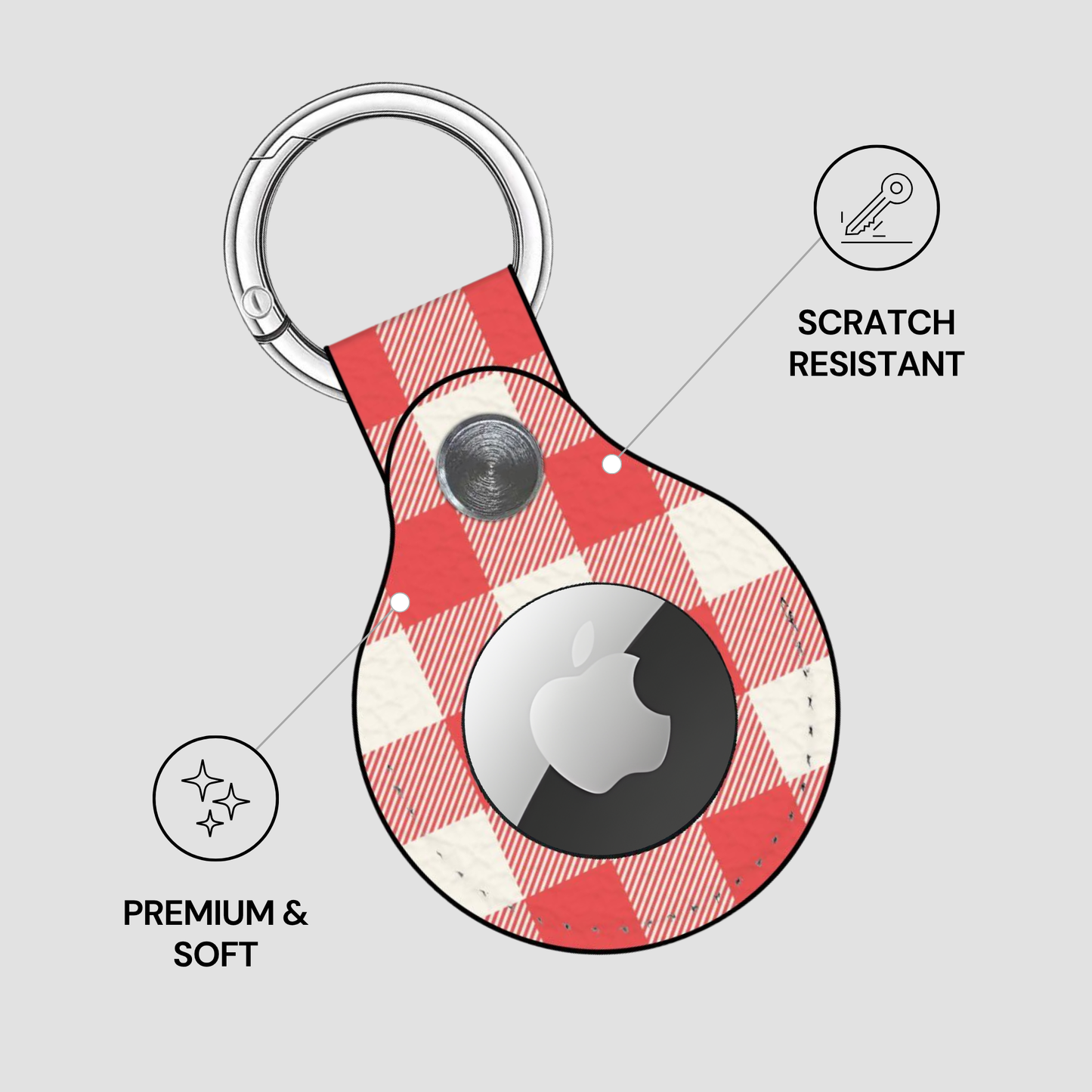 A red and white checkered leather keychain holder with a silver metal key ring, shown on a light gray background with feature callout icons and text reading 'SCRATCH RESISTANT' and 'PREMIUM & SOFT'.