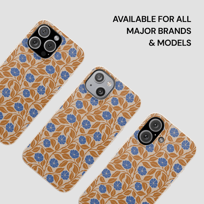 Three smartphone cases with a tan and blue floral pattern are shown on a light gray background, with text in the upper right reading 'AVAILABLE FOR ALL MAJOR BRANDS & MODELS'.
