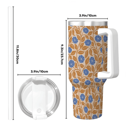 A tall handled tumbler with a beige background and a blue and tan floral pattern, shown with dimension lines and labels for height and lid diameter on a white background.