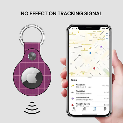 Purple Apple AirTag keychain with a phone displaying location tracking app on a light gray background