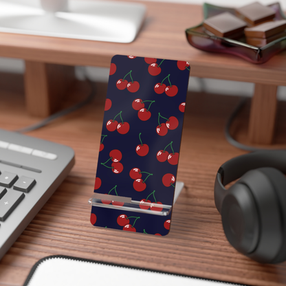 Phone stand with cherry pattern on a desk with keyboard, mouse, and headphones.