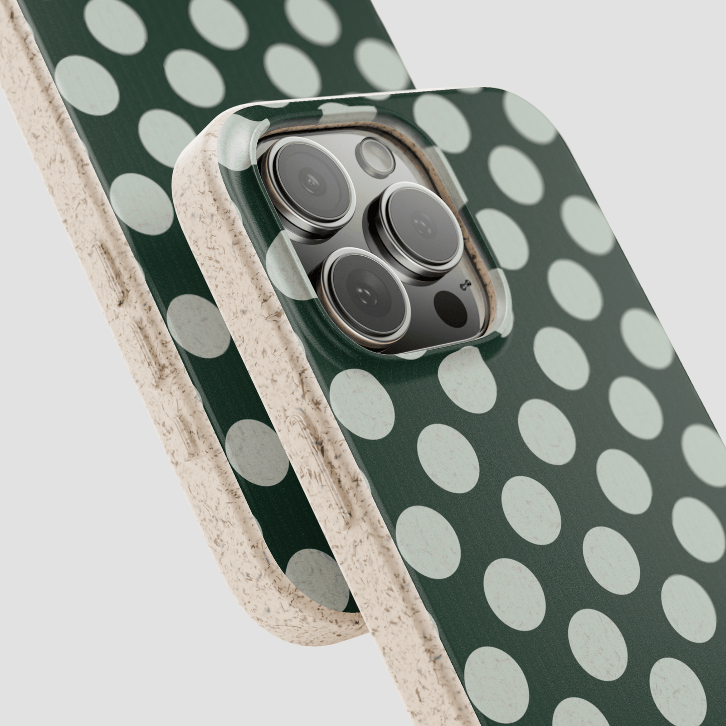 Phone case with green and white polka dot pattern on a light gray background