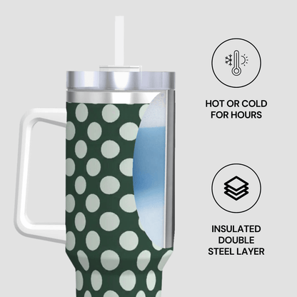 Green and white polka dot insulated tumbler with a straw on a light gray background