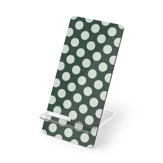 Phone stand with green and white polka dot design on a white background