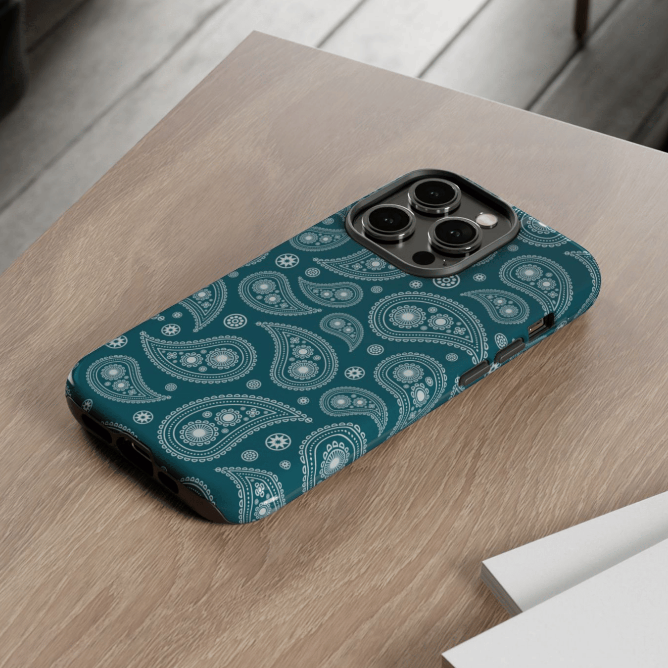 Phone case with paisley pattern on a wooden surface