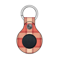 Plaid patterned keychain with a circular black component on a white background