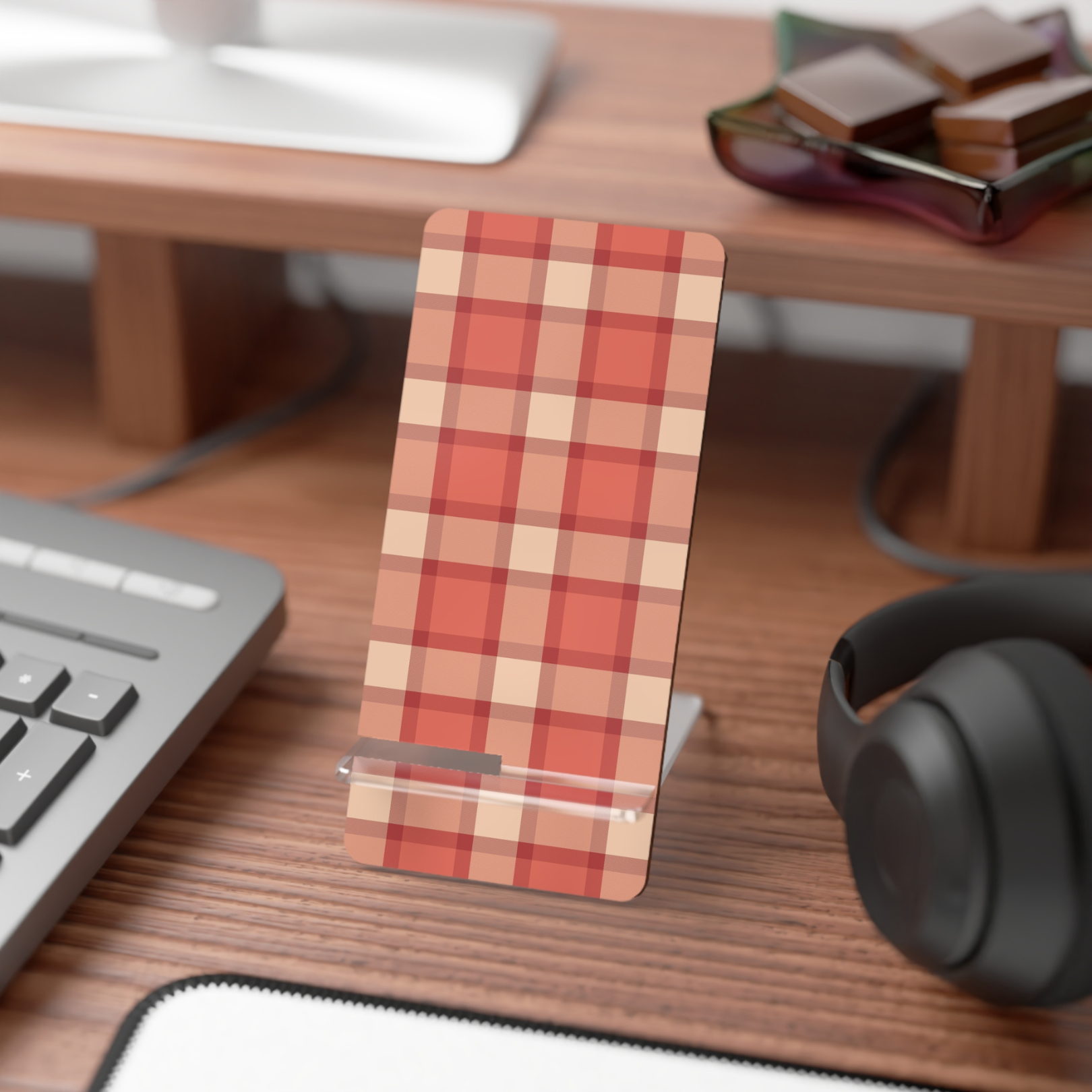 Plaid phone stand on a desk with keyboard, mouse, and headphones