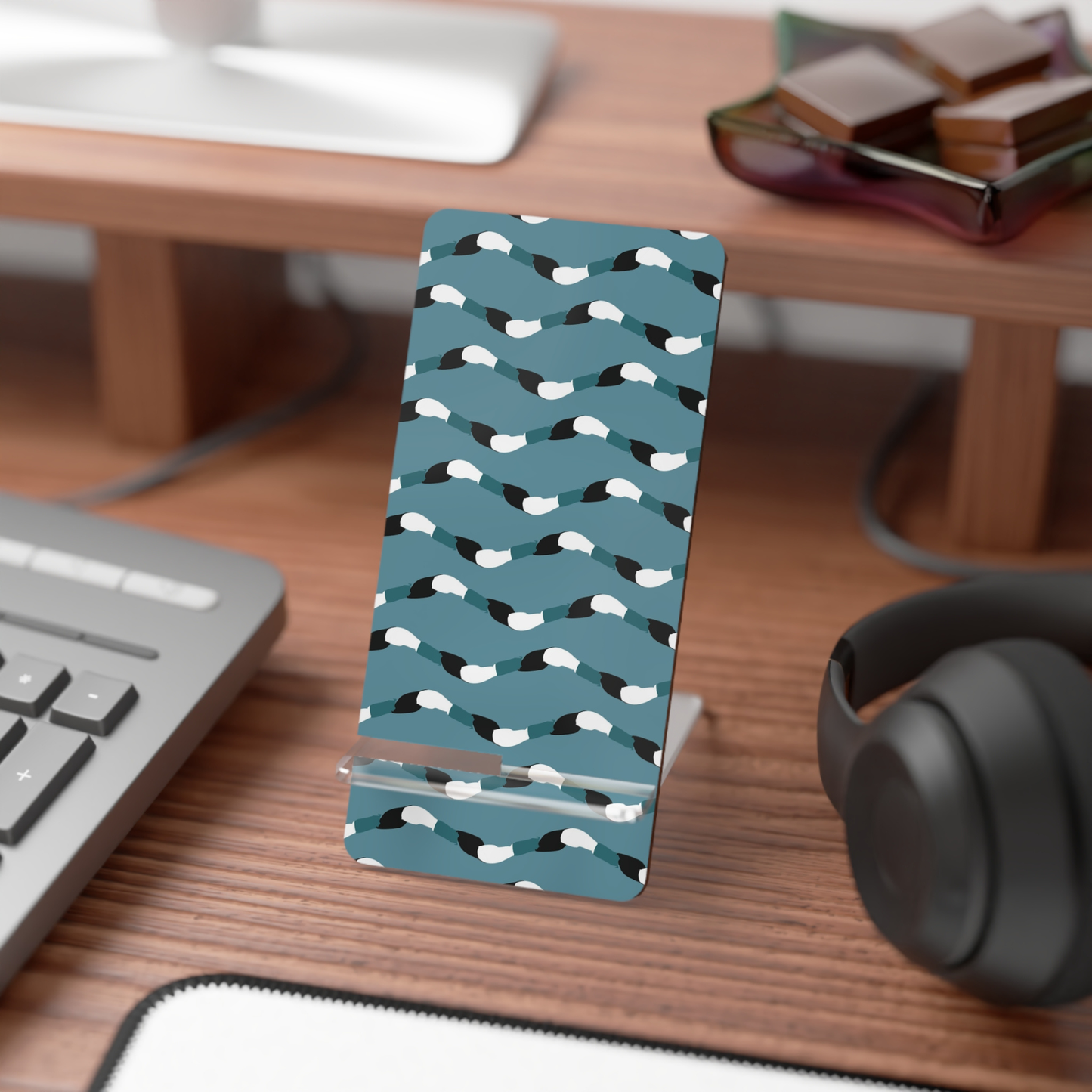 Phone case with bird pattern on a desk with keyboard and headphones