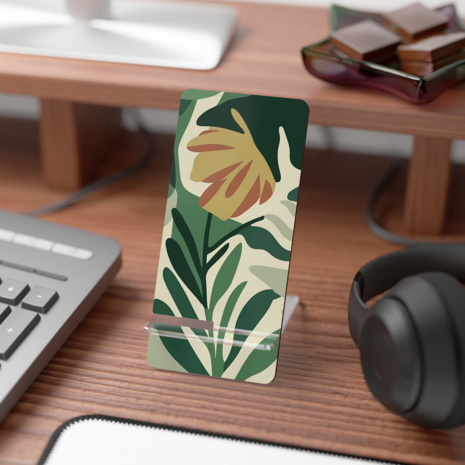 Floral phone stand on a desk with keyboard, mouse, and headphones