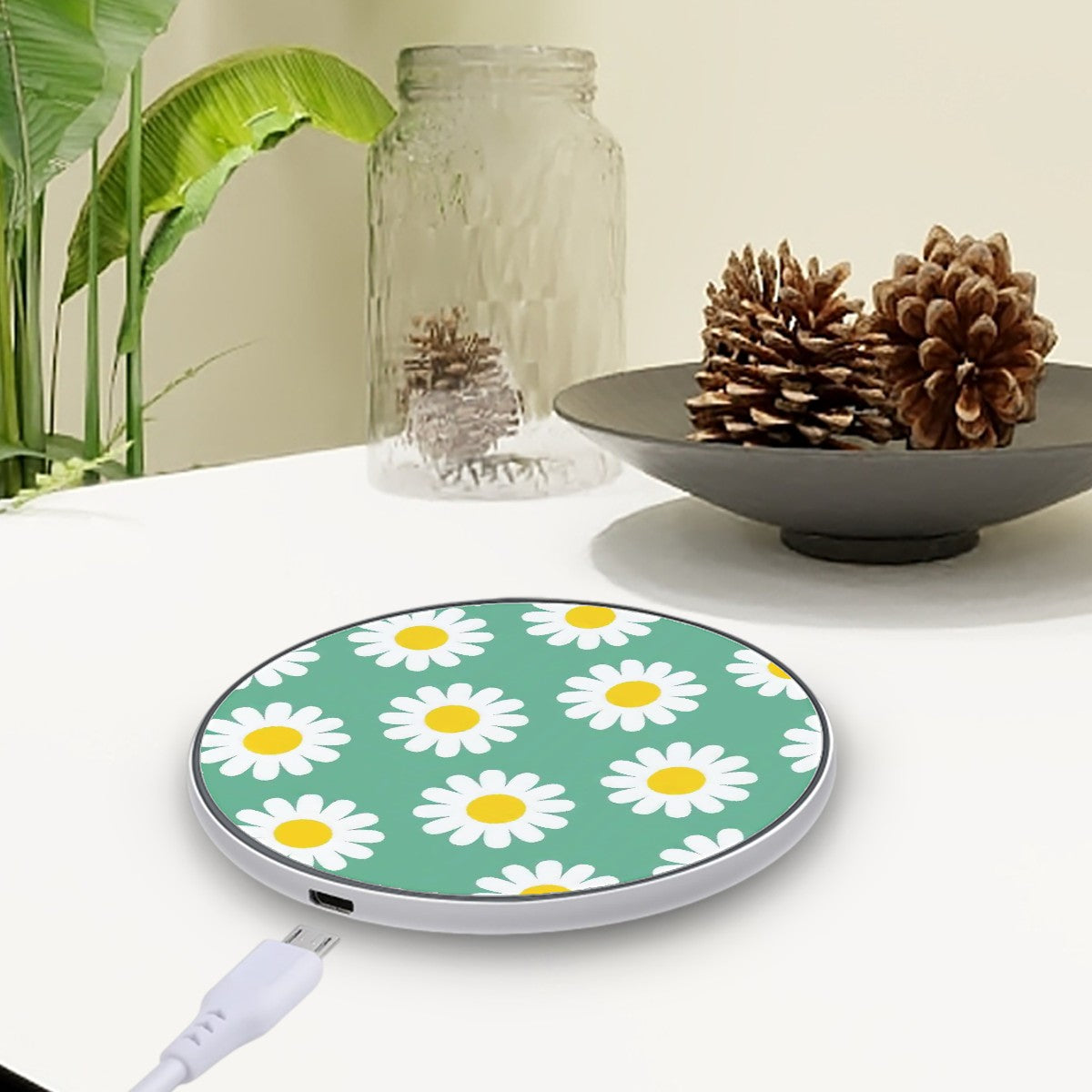 Wireless charger with daisy pattern on a table with decorative items